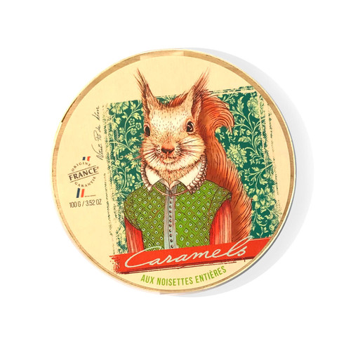 A Cornelius wooden round box from Mon Pari Gourmand containing 100 grams of hazelnuts caramels. On the front of the box is a medieval style painted portrait of a squirrel.
