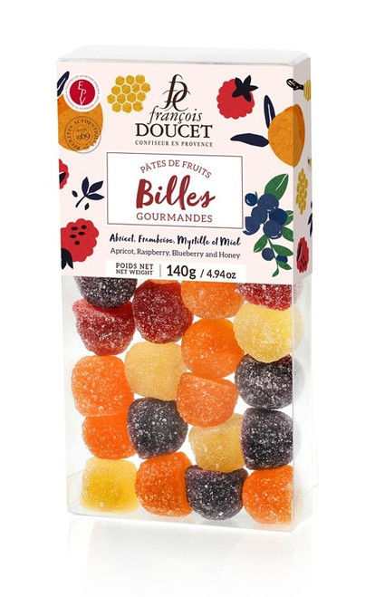 A clear box containing 140 grams of pâte de fruits "marbles" from François Doucet. The fruit jellies shaped as marbles come in a variety of colors: dark purple, yellow, orange, and red.