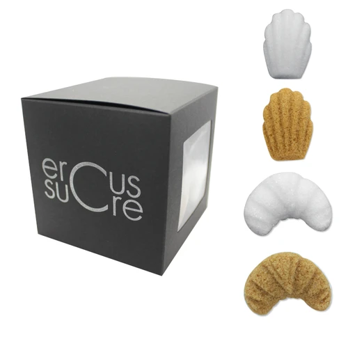 A black 120 gram box of individually wrapped Ercus madeleine and croissant-shaped sugar pieces. Sample white and brown madeleine and croissant pieces are displayed to the side of the box.
