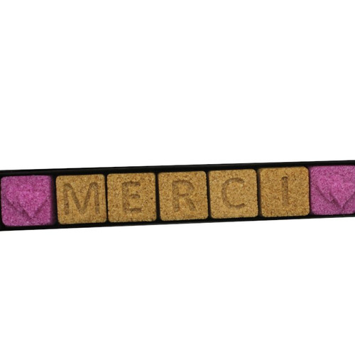A 35 gram sleeve of Ercus "Merci" sugar pieces. The seven red and brown square pieces each have a single character on them, spelling out the word "merci" padded with hearts.