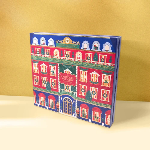 A Provence d'Antan "Nutcracker"-themed Advent calendar containing 24 different types of tea. The calendar shows a tall red building,  with several characters from "The Nutcracker" ballet are visible from the windows. The calendar sits on a yellow surface with a darker yellow background.