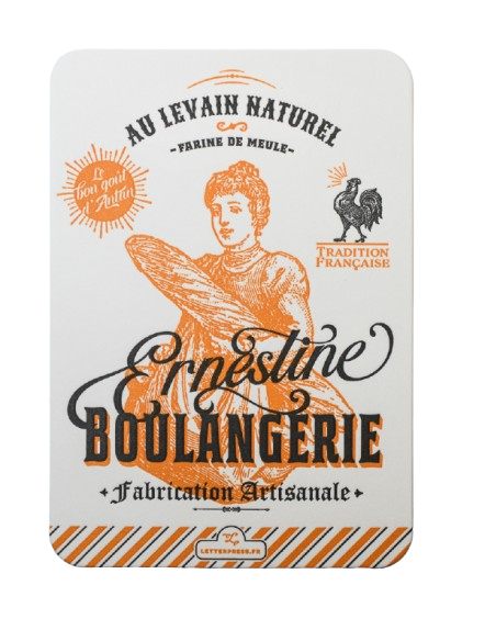 A "Boulangerie Ernestine" greeting card, hand printed by L'Atelier Letterpress. In the foreground is black text that reads "Au levain nature! Ernestine Boulangerie." Behind it is a golden sketch of a person holding bread.