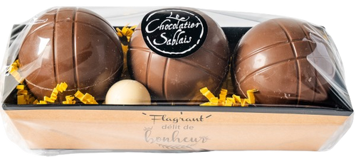 A tray containing 190 grams of milk chocolate pétanque balls from Le Chocolatier Sablais. The side of the tray says, "Flagrant délit de bonheur."