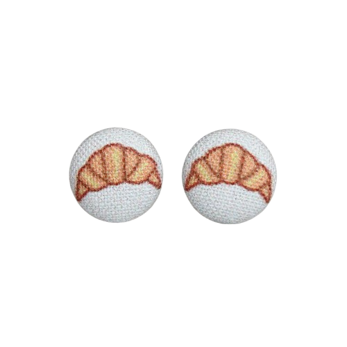 Two fabric button earrings with a cartoon croissant design on a white background, from Rachel O's.