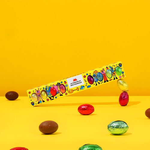 An 80 gram yellow box of assorted chocolate and gianduja eggs from Le Chocolat des Français. The eggs are covered in metal foil of a rainbow variety of colors.