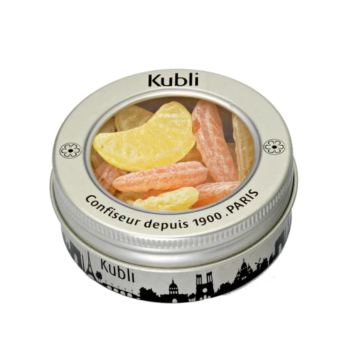 A 50 gram tin of Kubli candies shaped like orange and lemon wedges. The rim of the can is painted with the skyline of Paris.