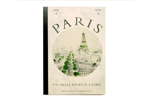 A notebook with an ivory retro Eiffel Tower illustration on its cover. The cover bottom reads "Une belle journée à Paris" (a beautiful day in Paris).