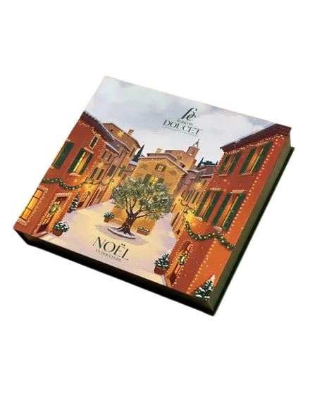 A 200 gram Advent calendar from François Doucet. The front of the calendar has a rich illustration of a snowy Provence village square with Christmas decorations, all done with varying shades of terra cotta.