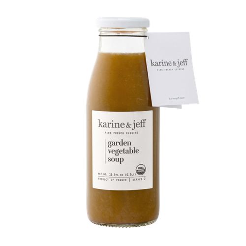 A 50 centiliter glass jar of organic garden vegetable soup from Karine & Jeff. The dark orange soup is opaque.