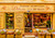 The well-lit storefront of "Délices du Luberon." Inside are an array of bottles and other products.