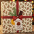 A 225 gram "holiday" box of Biscuiterie de Provence's gluten free almond cake with chocolate, walnut, and candied orange. The box features holly branches in old-fashioned design and a red ribbon.
