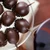 A top-down view of a tray holding several "La Guinette" dark chocolate-coated cherries with Armagnac, from Mademoiselle de Margaux.