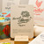A "Chou" card from L'Atelier Letterpress's "Excuse My French" series, displayed on a stand on a table. A sketch of a cabbage is at the top of the card. Below it in sweep cursive text reads, "Too much cabbage! Trop chou!"It is accompanied with an explanatory paragraph: "'Trop chou!' (meaning "so cute!") is a French expression that literally expresses one's fondness for something that one finds absolutely cute. It can also be used ironically."