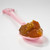 Muroise & Co's vineyard peach preserves on a pink spoon. The amber colored perserves appear to be thick and chunky