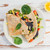 Two savory crêpes filled with vegetables sitting on a plate.