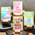 Four cards from L'Atelier Letterpress sit on display stands. They read, "coup de foundre" "cultivons notre amour," "la vie en rose fluo," and "sur un petit nuage."