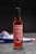 A 25 centiliter glass bottle from Martin-Pouret containing Orléans red wine vinegar. The bottle sits on a stone countertop with a French flag behind it.