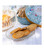 Five butter cookies with caramel chips on a glass plate. Besides it is an open "Bouquet Savage" tin from La Sablésienne.