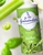A green canister containing 250 grams of Le Guérandais fine sea salt with organic herbs being tossed alongside herbs and vegetables.