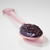 Muroise & Co's dark chocolate raspberry jam on a pink spoon. The dark purple jam appears smooth and spreadable.