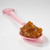 Muroise & Co Roussillon organic red rhubarb preserves on a pink spoon. The orange-red preserves are rich and hold their shape.