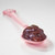 Muroise & Co organic Christmas jam with fig, almond and Port wine on a pink spoon. The purple jam is relatively smooth.