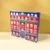 A Provence d'Antan "Nutcracker"-themed Advent calendar containing 24 different types of tea. The calendar shows a tall red building,  with several characters from "The Nutcracker" ballet are visible from the windows. The calendar sits on a yellow surface with a darker yellow background.