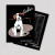 The front and back of the black painting dog notebook from Laughing Elephant. The front has a drawing of a white terrier holding a used paint brush while sitting atop a paint palette. The back has a multiplication table in white text.