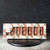 A 110 gram box of marshmallows covered in milk and dark chocolate, shaped into bears. From Le Chocolatier Sablais. The box is on a wooden coaster on a stone countertop.