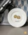 A white dessert plate with a French pastry illustration (chouquettes).
