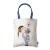 A cotton tote bag illustrated with a typical young Paris girl kissing an Eiffel Tower snow ball.