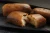 Three rectangular babas au rhum on a tray. The baba on the foreground is open, showing its moist inside.