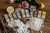 An assortment of loose mints sitting on a table spread, each coming out of one of the many flavors of Anis de Flavigny. The mints are surrounded by objects representing the flavors: a lemon, star anise, a pink rose, etc.
