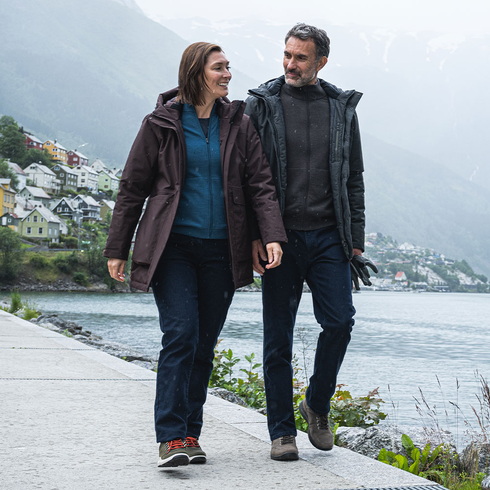 Man and woman wearing Rohan insulated jeans whilst walking in a Nordic City