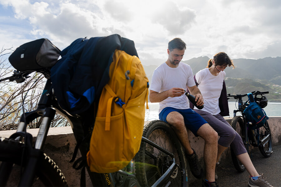 Man and Woman on Sitting on a Cycling Break in Lightweight Sports Clothing