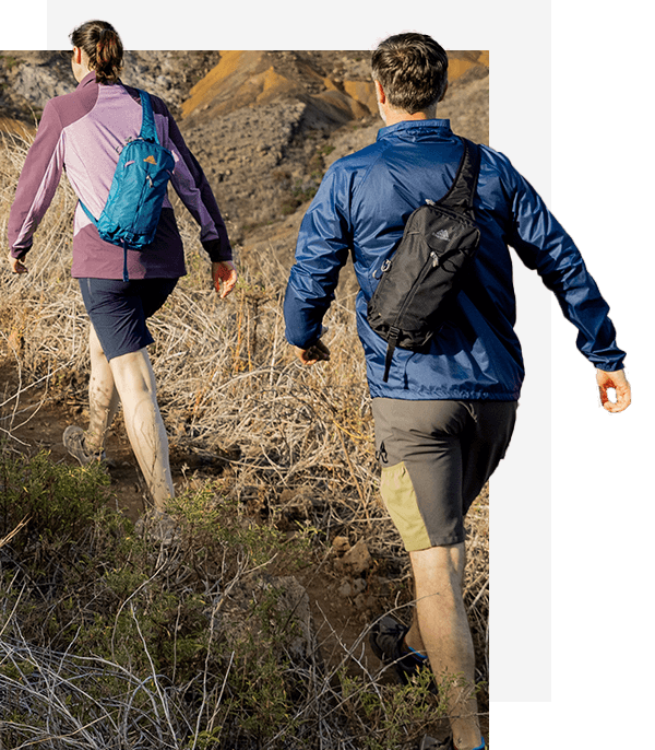 Man and woman hiking wearing Gregory Nano Sling bags