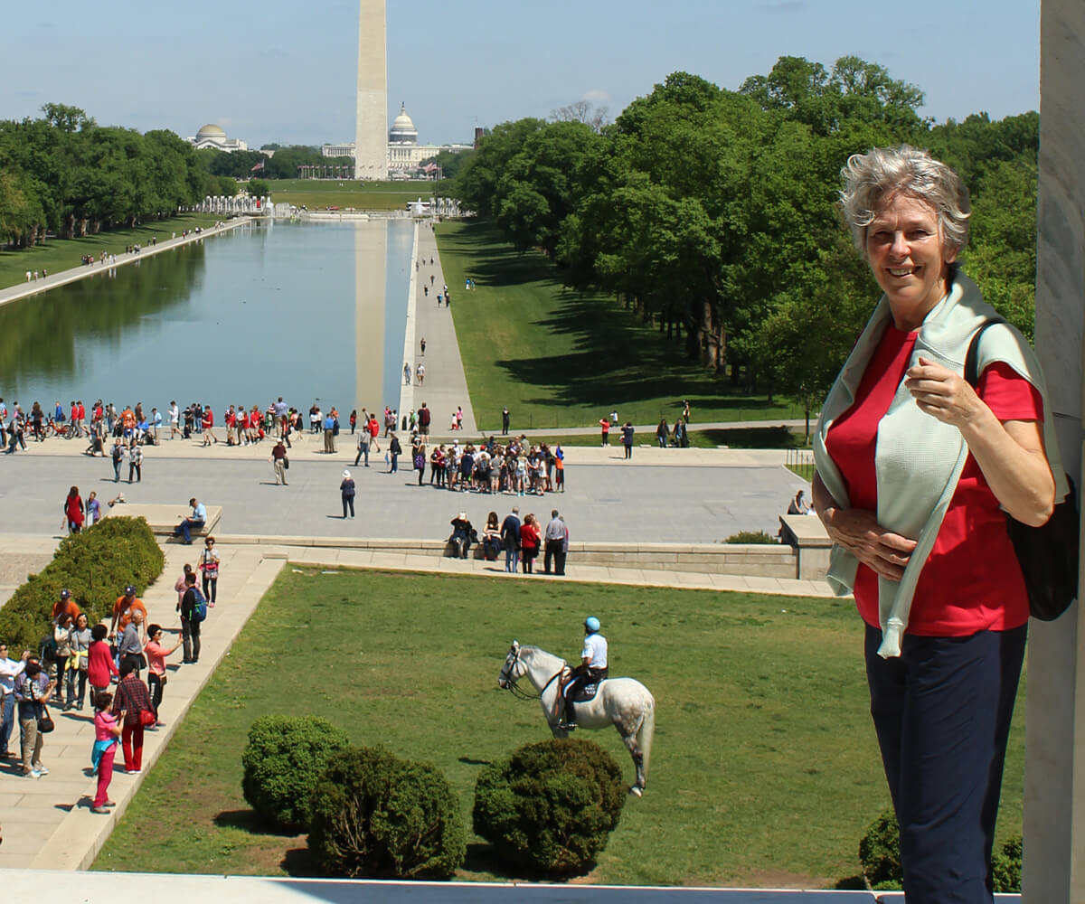 Liz stood in front of water and monument in Washington.