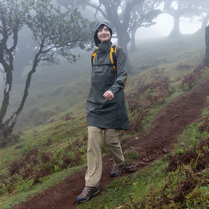 Woman wearing the Unisex Tamar Waterproof Overhead  in Park Green colour, in the foggy woodland.