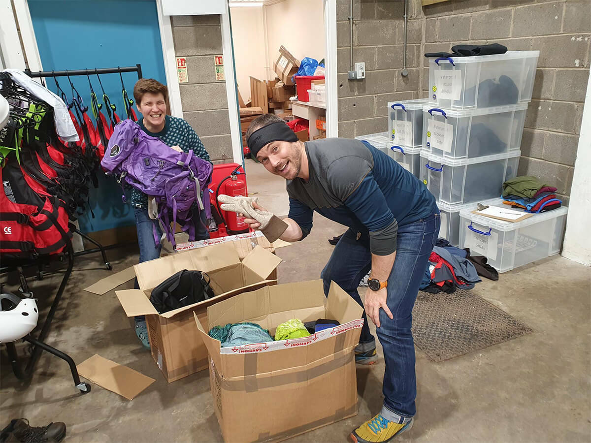 Staff at Venture Scotland unpacking boxes of Gift Your Gear donations