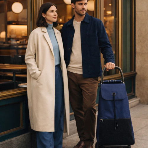 Pareja posando con carro de compra Rolser azul-negro en entorno urbano