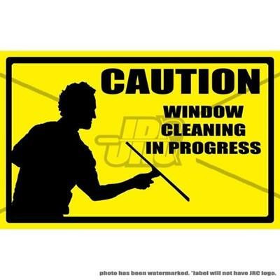 ProTool Window Cleaning In Progress Label, caution sign with a silhouette of a person cleaning a window and the text 'Caution Window Cleaning In Progress' in bold black font on a yellow background.