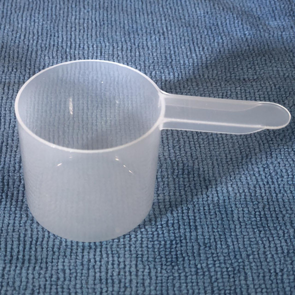 ProTool Scoop for Measuring 2oz - 63cc, transparent plastic measuring scoop on blue textured surface.