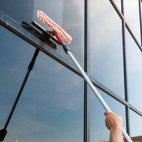 Pulex TechnoDuo Stainless Steel, window cleaning tool with microfiber pad being used to clean the exterior glass of a modern building.