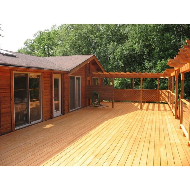 J.Racenstein Medford Cedar Deck & Wood Stain DRP, outdoor cedar deck with new wooden flooring and railing near a house surrounded by green trees.