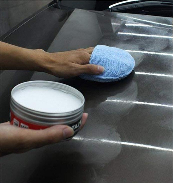 ProTool Polishing Pad Blue Microfiber, close-up of a hand polishing a car surface with the microfiber pad in a garage setting.