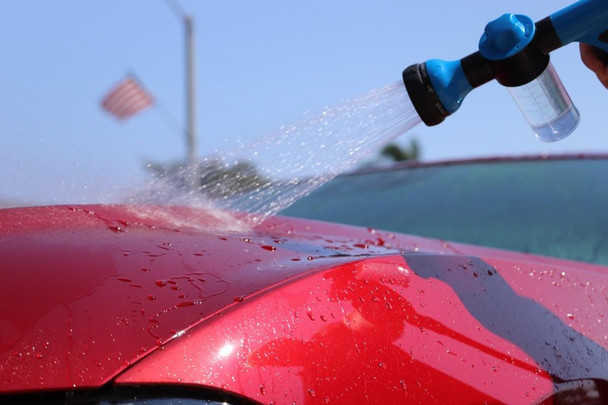 ProTool Wash Up Soap 1/2 gal, a bottle being used to spray soap onto a red car for cleaning.