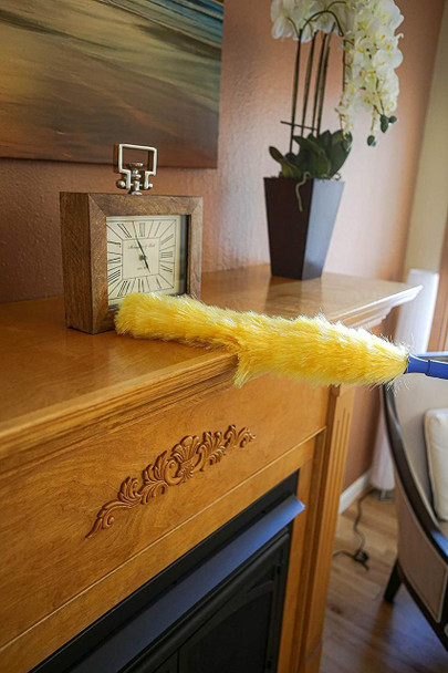 Ettore Duster Static Ettore, yellow feather duster placed on wooden fireplace mantel with clock and plant in background.