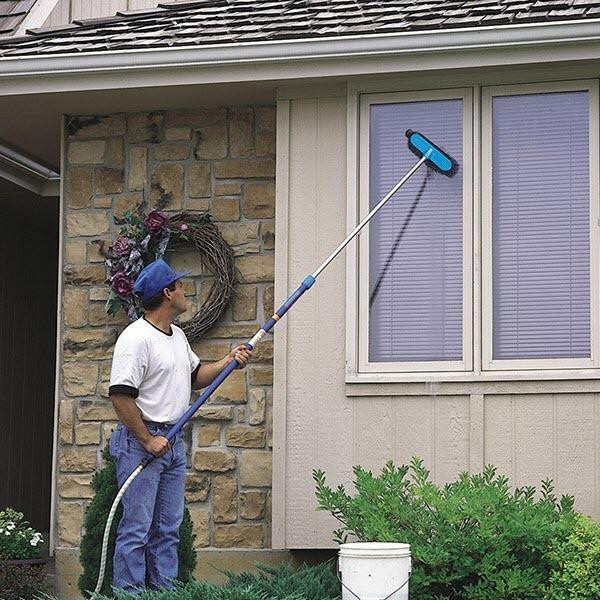 J.Racenstein Pole HydraSoar FloThru 12ft, person cleaning exterior window with telescopic pole and cleaning pad, outdoor house with stone and siding, garden and wreath decor.