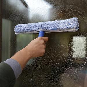 Ettore Professional Window Cleaning Kit w/soap, person cleaning window with a squeegee and soap