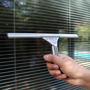 Ettore Professional Window Cleaning Kit w/soap, hand holding squeegee cleaning window blinds with soap solution.
